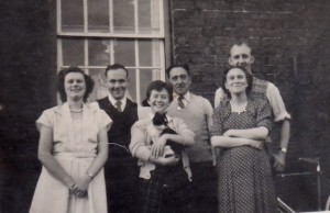 Burnham family gathering l to r: Edna (nee Lane); ?; Ann; Joe; Doreen Langton (nee Burnham); Rex Langton; with Emma Burnham observing through the window.